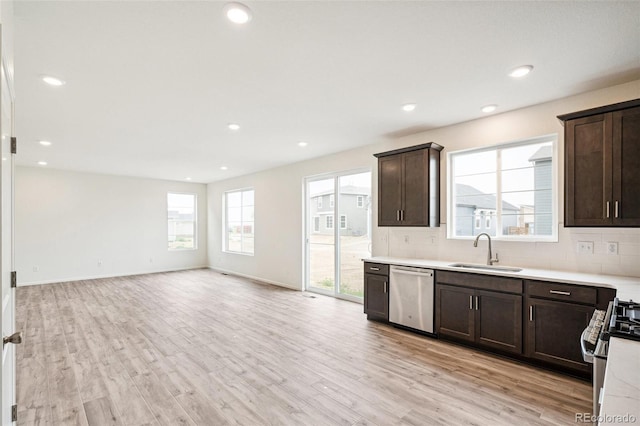 kitchen featuring stainless steel appliances, tasteful backsplash, sink, and light wood-type flooring