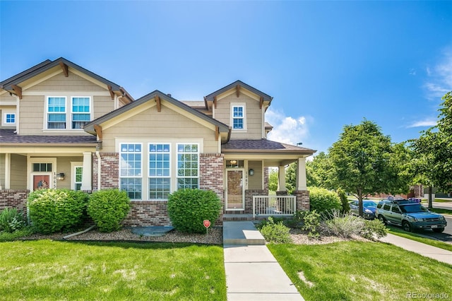 1067 Uinta Way Unit 1067, Denver, CO 80230 - craftsman house with covered porch, a front yard, brick siding, and roof with shingles
