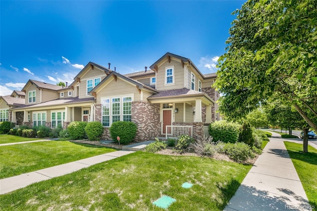 1067 Uinta Way Unit 1067, Denver, CO 80230 - craftsman-style home with covered porch, a front yard, brick siding, and stone siding