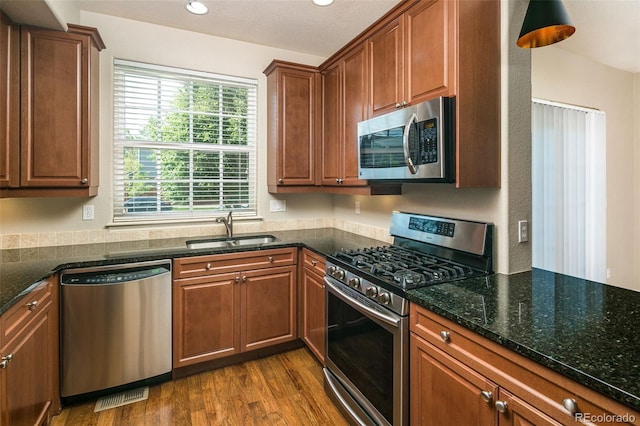1067 Uinta Way Unit 1067, Denver, CO 80230 - kitchen featuring stainless steel appliances, dark wood finished floors, dark stone counters, and recessed lighting