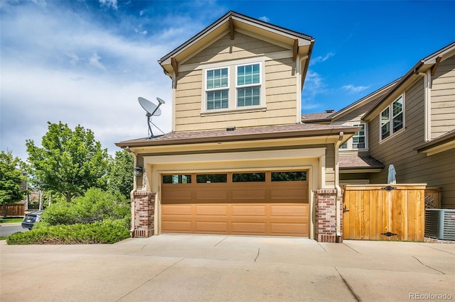 1067 Uinta Way Unit 1067, Denver, CO 80230 - view of front facade featuring a garage, concrete driveway, brick siding, and a shingled roof