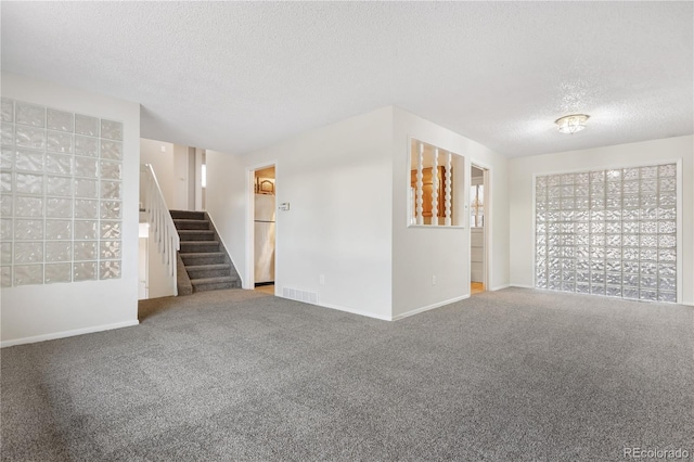 unfurnished room featuring carpet and a textured ceiling