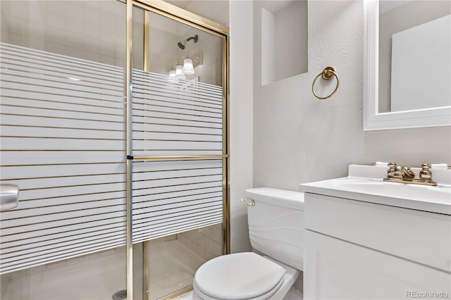 bathroom featuring an enclosed shower, vanity, and toilet