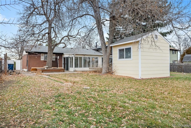 back of house featuring a sunroom and a yard