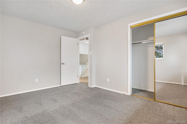 unfurnished bedroom with a closet, carpet, and a textured ceiling