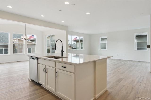 8205 Cokedale Cir, Littleton, CO 80125 - kitchen with stainless steel dishwasher, a sink, a chandelier, light wood-style floors, and recessed lighting