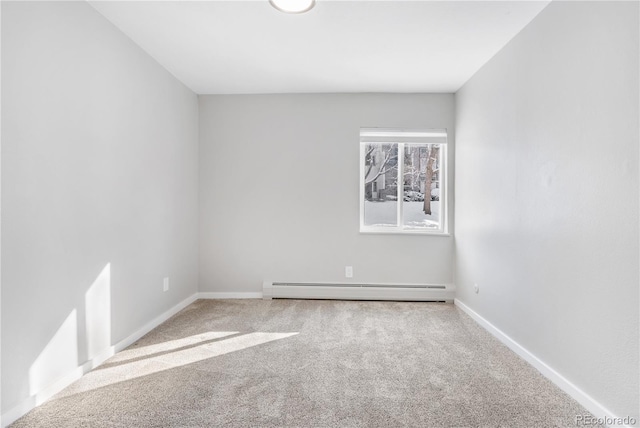 spare room featuring a baseboard heating unit and carpet flooring