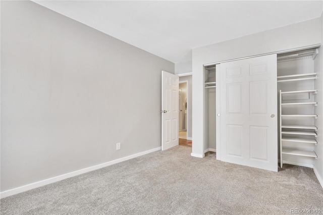 unfurnished bedroom featuring light colored carpet and a closet