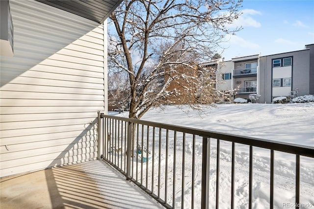 view of snow covered back of property