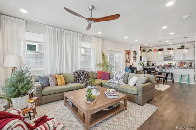 living room featuring light hardwood / wood-style flooring and ceiling fan