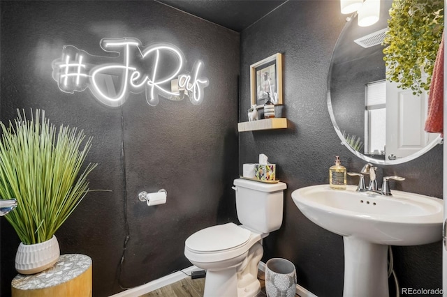 bathroom featuring hardwood / wood-style flooring and toilet