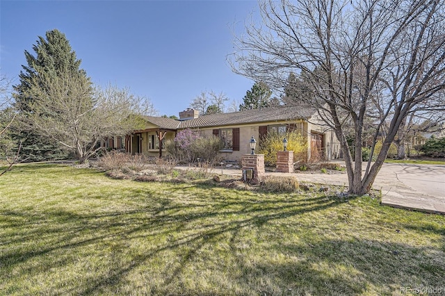 ranch-style house featuring a chimney and a front lawn
