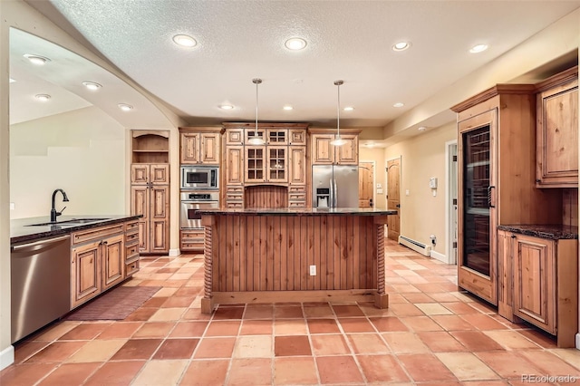 kitchen with recessed lighting, stainless steel appliances, a sink, a baseboard heating unit, and a kitchen island