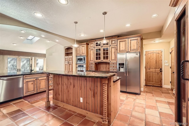 kitchen with stainless steel appliances, a kitchen breakfast bar, a sink, glass insert cabinets, and a kitchen island