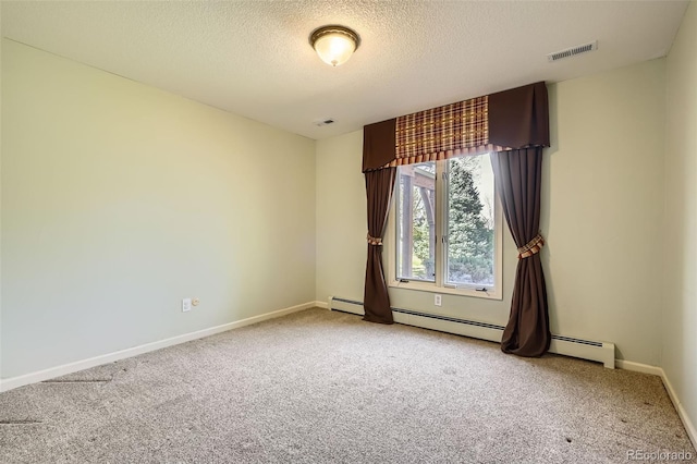 carpeted empty room featuring baseboards, baseboard heating, visible vents, and a textured ceiling