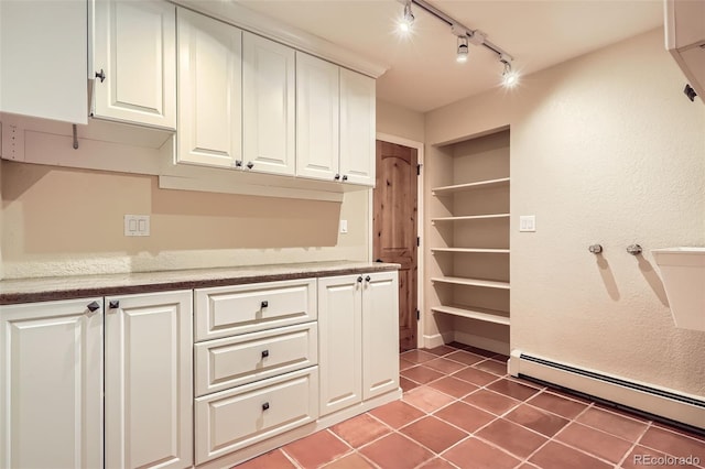 interior space with a baseboard radiator, track lighting, and light tile patterned flooring