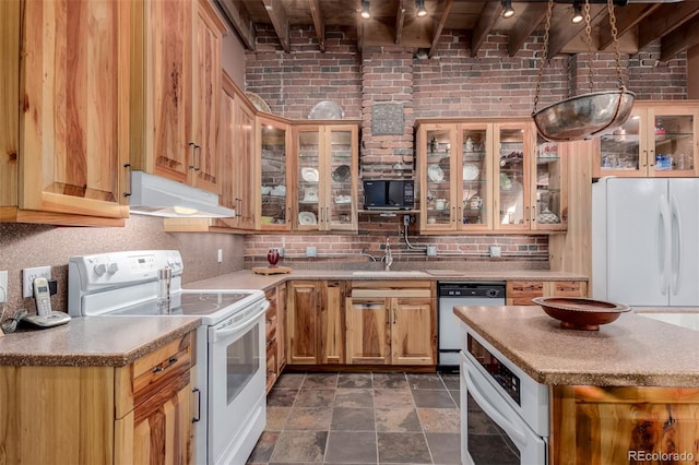 kitchen featuring beamed ceiling, white appliances, sink, and brick wall