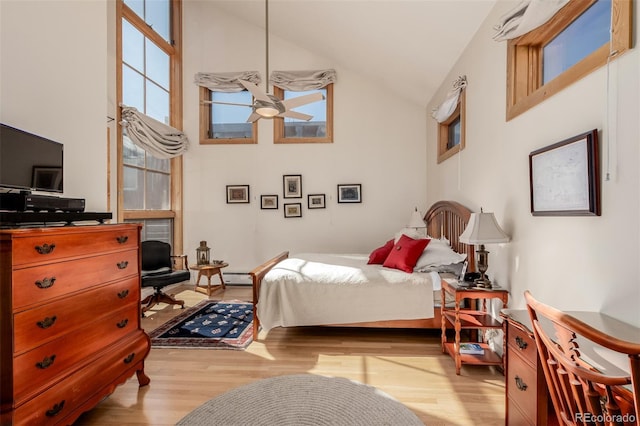 bedroom with ceiling fan, light wood-type flooring, and high vaulted ceiling