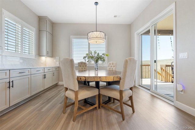 dining room featuring light wood-type flooring and a healthy amount of sunlight