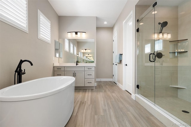 bathroom featuring hardwood / wood-style flooring, vanity, and independent shower and bath