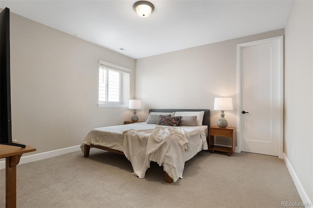 bedroom featuring light carpet and baseboards