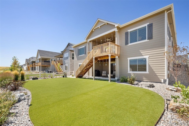 rear view of property featuring ceiling fan, a lawn, and a patio