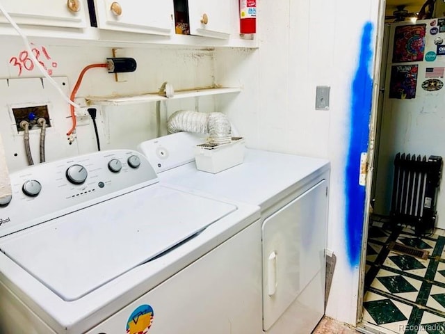 washroom with cabinet space, separate washer and dryer, and light flooring