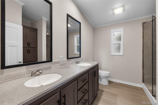 bathroom featuring toilet, hardwood / wood-style flooring, walk in shower, crown molding, and vanity