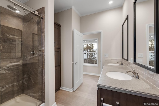 bathroom featuring a shower with shower door, vanity, crown molding, and hardwood / wood-style flooring