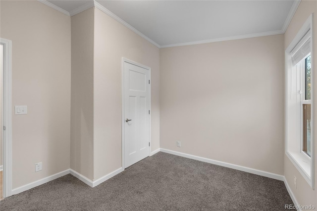 spare room featuring crown molding and dark colored carpet