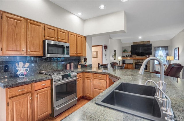 6112 Alkire Ct, Arvada, CO 80004 - kitchen featuring stainless steel appliances, open floor plan, backsplash, light wood-style flooring, and recessed lighting