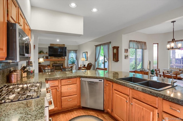 6112 Alkire Ct, Arvada, CO 80004 - kitchen featuring appliances with stainless steel finishes, light wood finished floors, tile counters, a chandelier, and recessed lighting