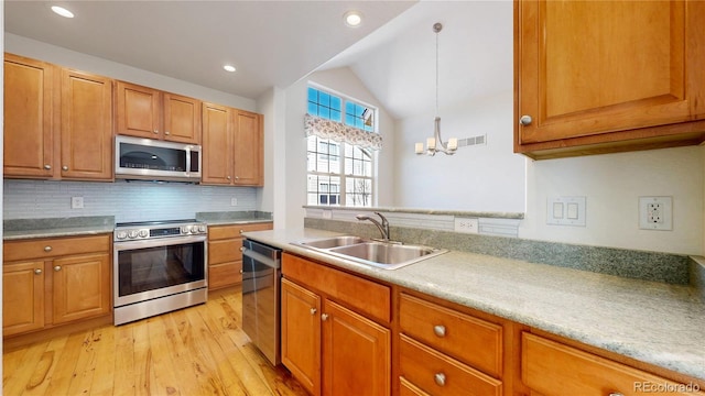 kitchen with stainless steel appliances, light countertops, a sink, and visible vents