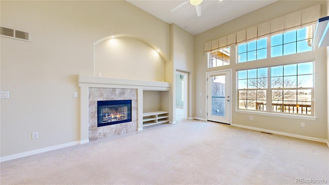 unfurnished living room with carpet flooring, plenty of natural light, visible vents, and baseboards