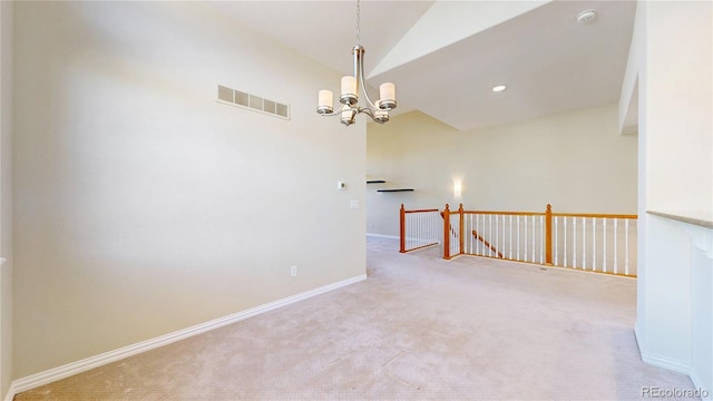 empty room with visible vents, baseboards, lofted ceiling, an inviting chandelier, and carpet