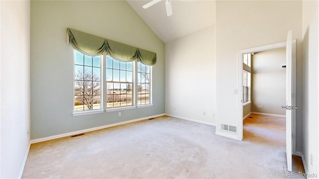 carpeted empty room featuring baseboards, high vaulted ceiling, visible vents, and a ceiling fan