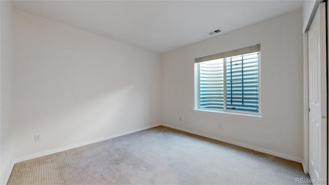 carpeted empty room with visible vents and baseboards