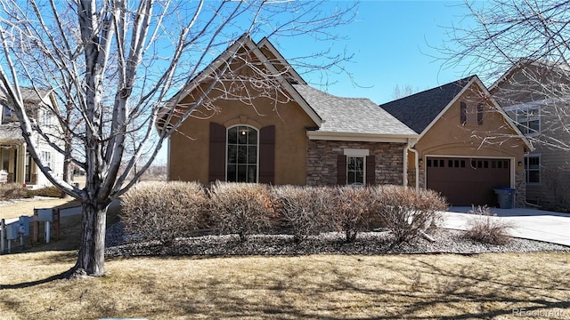 view of front of house with stone siding, stucco siding, concrete driveway, and a shingled roof