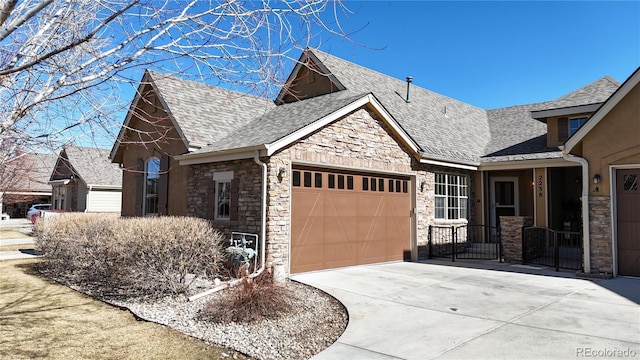2238 Calais Dr Unit B, Longmont, CO 80504 - view of front of property with a garage, concrete driveway, roof with shingles, and stone siding