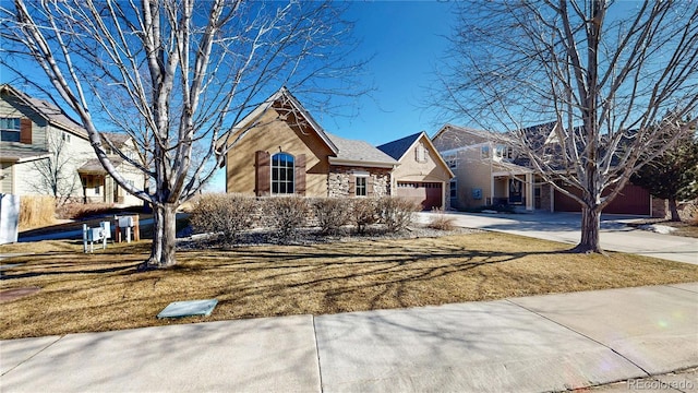 2238 Calais Dr Unit B, Longmont, CO 80504 - view of front of home with an attached garage, concrete driveway, a front yard, and stone siding