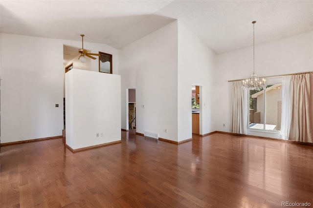 spare room featuring ceiling fan with notable chandelier, high vaulted ceiling, and dark hardwood / wood-style flooring