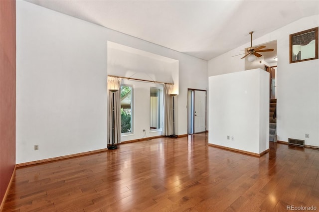 empty room with lofted ceiling, hardwood / wood-style floors, and ceiling fan