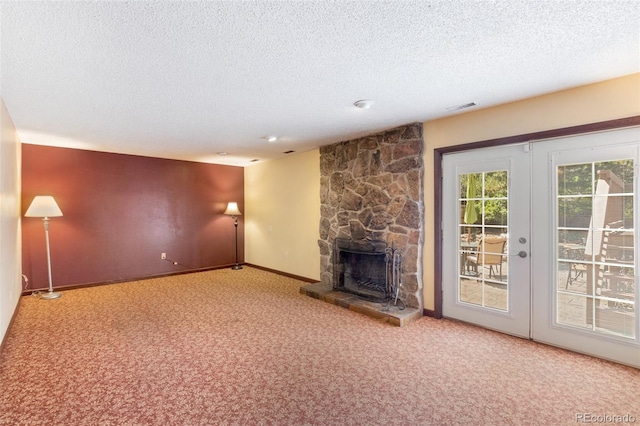 unfurnished living room with carpet floors, a textured ceiling, and a fireplace