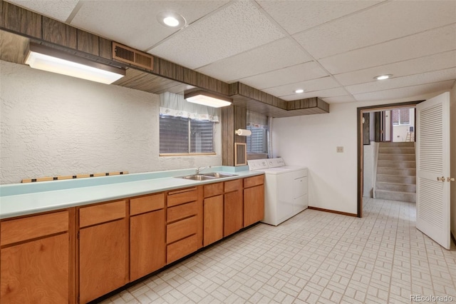 kitchen featuring a drop ceiling, sink, and washer / dryer