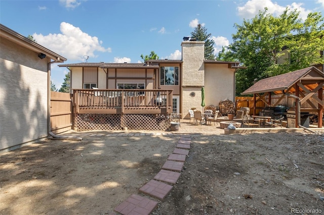 back of property with a wooden deck, a patio, and a gazebo