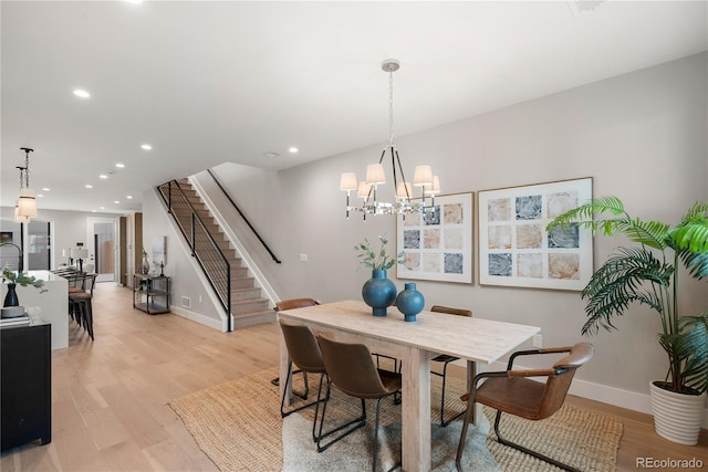 dining room featuring light wood-type flooring and a notable chandelier