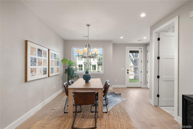 dining room with light hardwood / wood-style floors and an inviting chandelier