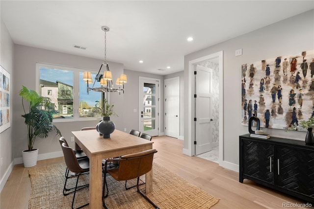 dining room with plenty of natural light, light hardwood / wood-style floors, and a chandelier