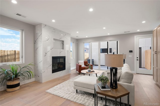 living room featuring light hardwood / wood-style flooring and a premium fireplace