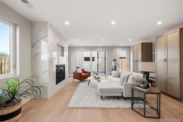 living room with light wood-type flooring and a premium fireplace